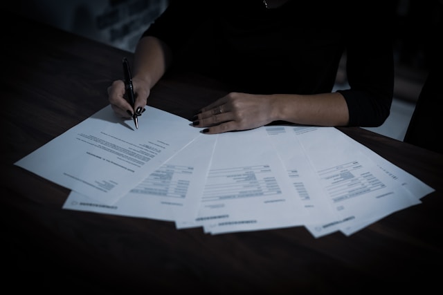 immagine esemplificativa di preventivo. mano di persona che controlla vari fogli per accettazione